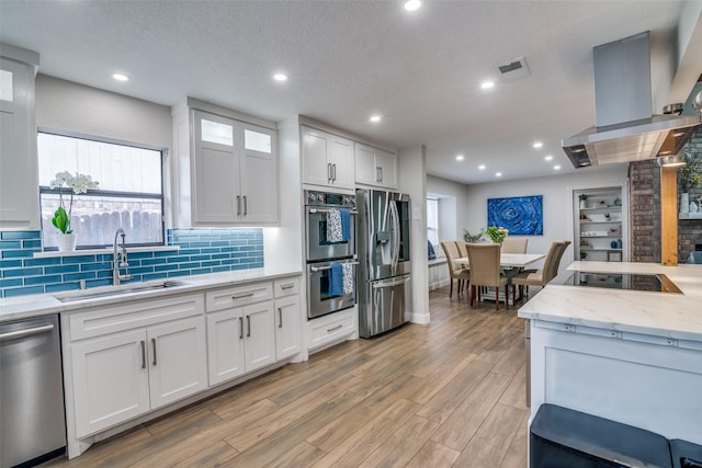 1316 Devonshire Ln, Mesquite, TX 75150 - kitchen with a sink, appliances with stainless steel finishes, decorative backsplash, white cabinetry, and recessed lighting