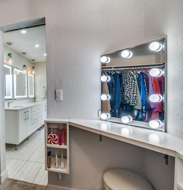1316 Devonshire Ln, Mesquite, TX 75150 - kitchen with a textured wall, white cabinetry, light countertops, light tile patterned flooring, and a sink