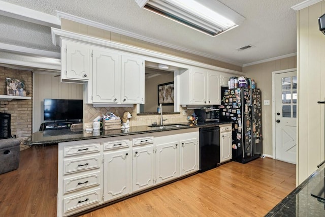 2916 Lafayette St, Corsicana, TX 75110 - kitchen with a sink, black appliances, white cabinets, ornamental molding, and light wood finished floors