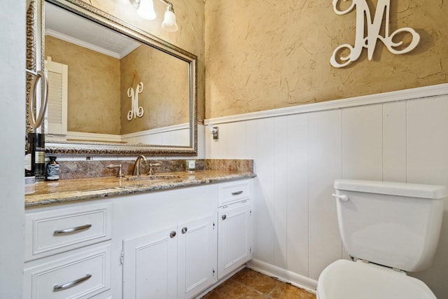 2916 Lafayette St, Corsicana, TX 75110 - bathroom with wainscoting, a decorative wall, vanity, and toilet