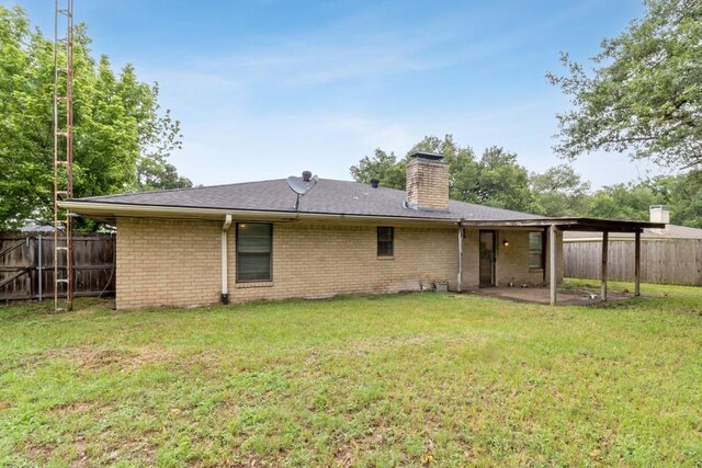 2916 Lafayette St, Corsicana, TX 75110 - back of house with a chimney, brick siding, and a patio area