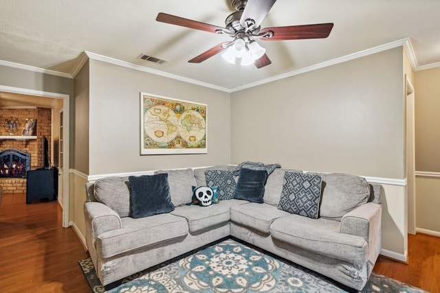 2916 Lafayette St, Corsicana, TX 75110 - living area with wood finished floors, a ceiling fan, crown molding, a brick fireplace, and baseboards