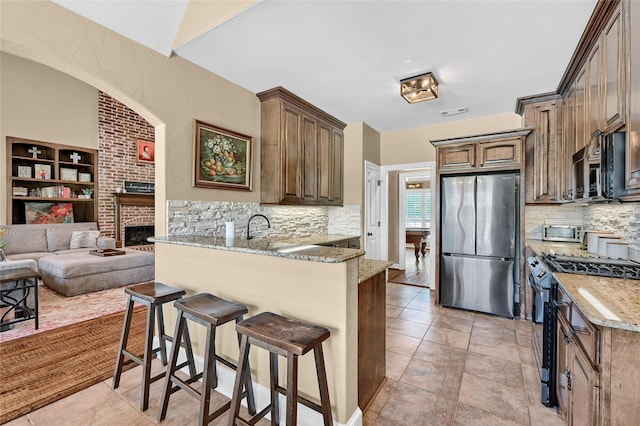 30 Tananger Springs Dr, Denison, TX 75021 - kitchen with freestanding refrigerator, gas range oven, black microwave, and decorative backsplash