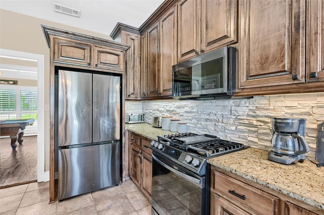 30 Tananger Springs Dr, Denison, TX 75021 - kitchen featuring stainless steel appliances, light stone counters, and decorative backsplash