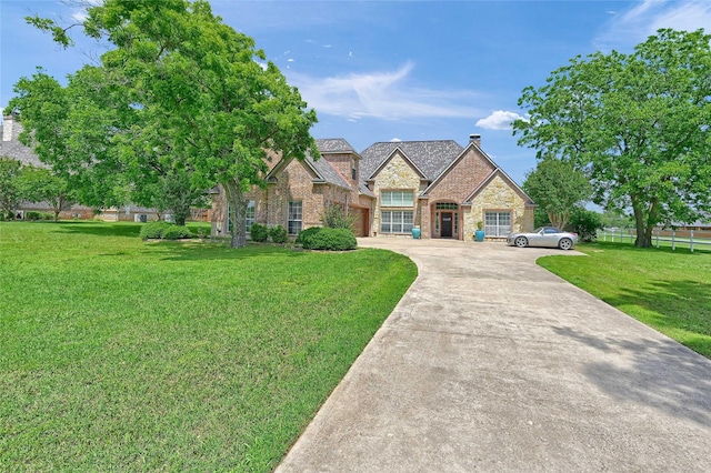 30 Tananger Springs Dr, Denison, TX 75021 - french country style house featuring driveway, stone siding, a front yard, an attached garage, and brick siding