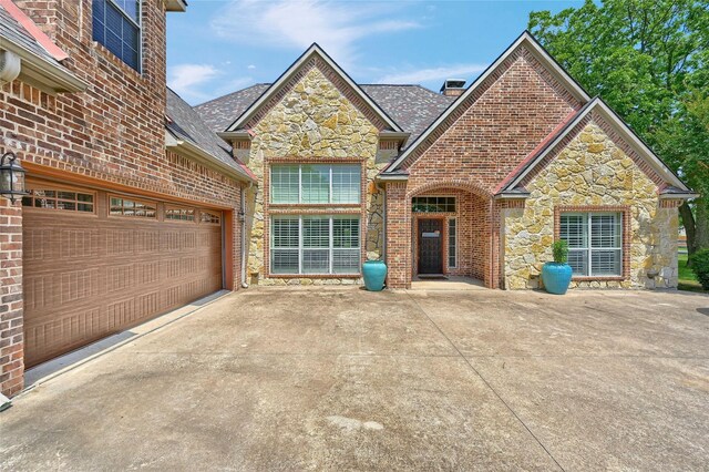 30 Tananger Springs Dr, Denison, TX 75021 - traditional-style home with stone siding, concrete driveway, brick siding, a garage, and a shingled roof