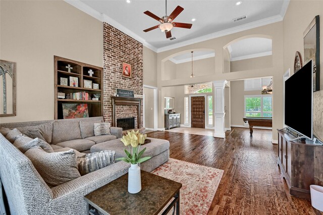 30 Tananger Springs Dr, Denison, TX 75021 - living area with decorative columns, a brick fireplace, a high ceiling, a ceiling fan, and wood finished floors