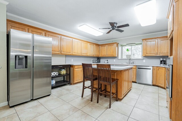 9390 Adams St, Terrell, TX 75160 - kitchen with appliances with stainless steel finishes, crown molding, a center island, a ceiling fan, and light countertops