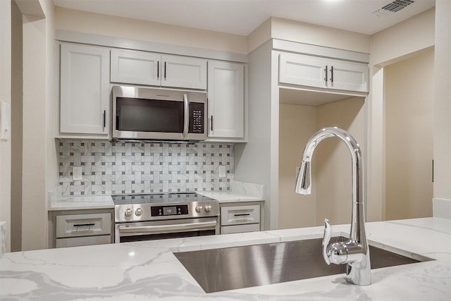 7013 Buttonwood Dr, Fort Worth, TX 76137 - kitchen with stainless steel appliances, tasteful backsplash, and light stone countertops