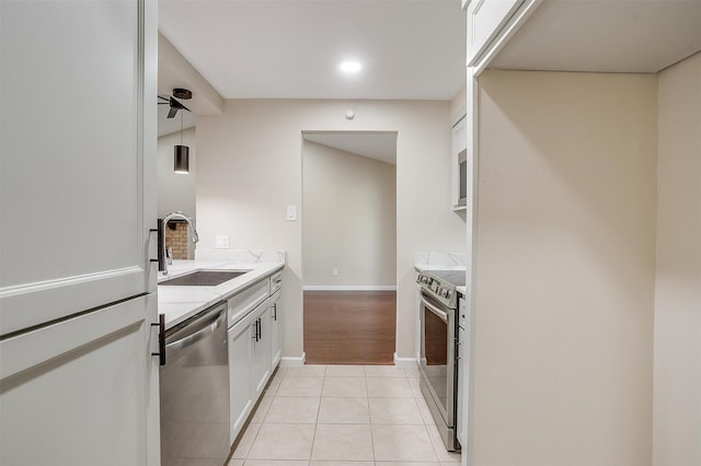 7013 Buttonwood Dr, Fort Worth, TX 76137 - kitchen featuring stainless steel appliances, a sink, white cabinetry, light tile patterned floors, and baseboards