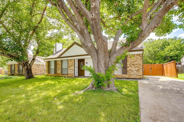 7013 Buttonwood Dr, Fort Worth, TX 76137 - view of front facade with brick siding, a chimney, a gate, and concrete driveway