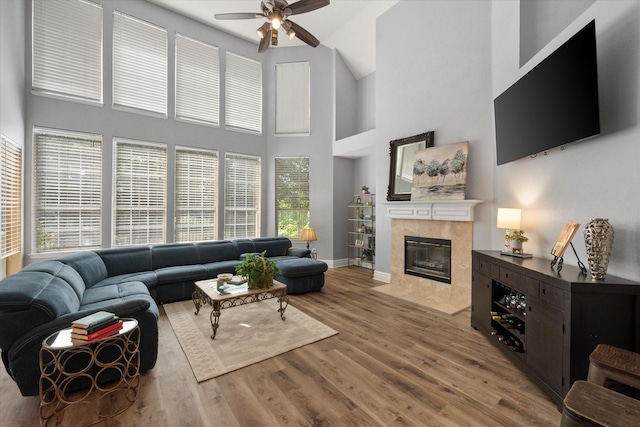4710 Safe Harbour Dr, Arlington, TX 76016 - living room with a ceiling fan, a tile fireplace, wood finished floors, a high ceiling, and baseboards