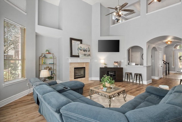 4710 Safe Harbour Dr, Arlington, TX 76016 - living room with arched walkways, ceiling fan, a high ceiling, baseboards, and wood finished floors