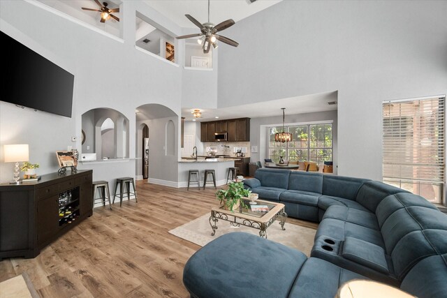 4710 Safe Harbour Dr, Arlington, TX 76016 - living area with a ceiling fan, light wood-type flooring, a towering ceiling, and arched walkways