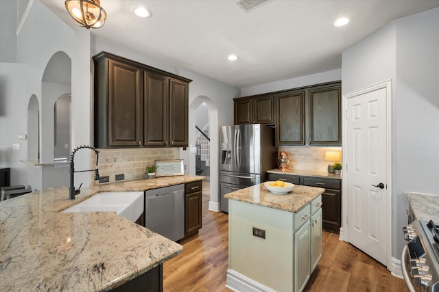 4710 Safe Harbour Dr, Arlington, TX 76016 - kitchen with stainless steel appliances, arched walkways, a sink, backsplash, and dark brown cabinetry