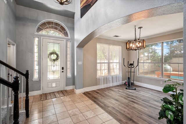4710 Safe Harbour Dr, Arlington, TX 76016 - entrance foyer featuring a chandelier, arched walkways, baseboards, crown molding, and wood finished floors