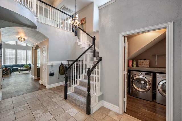 4710 Safe Harbour Dr, Arlington, TX 76016 - stairs featuring separate washer and dryer, arched walkways, tile patterned flooring, baseboards, and a chandelier