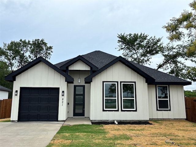 821 Rayenell Ave, Dallas, TX 75217 - view of front of home featuring a garage, concrete driveway, roof with shingles, and board and batten siding