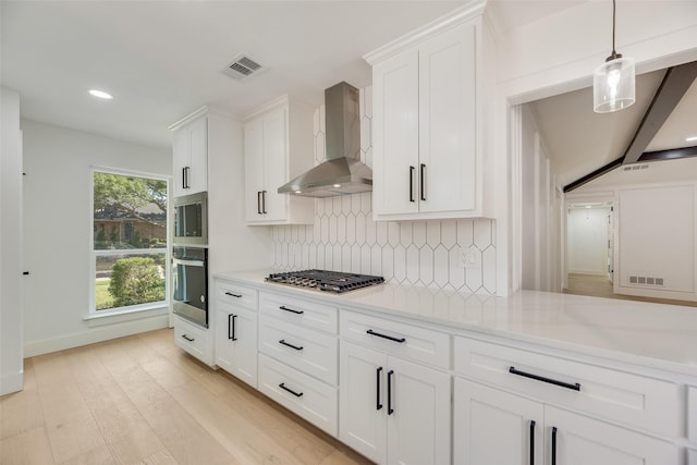 3620 Big Horn Trl, Plano, TX 75075 - kitchen with stainless steel appliances, wall chimney exhaust hood, decorative backsplash, white cabinetry, and light wood finished floors