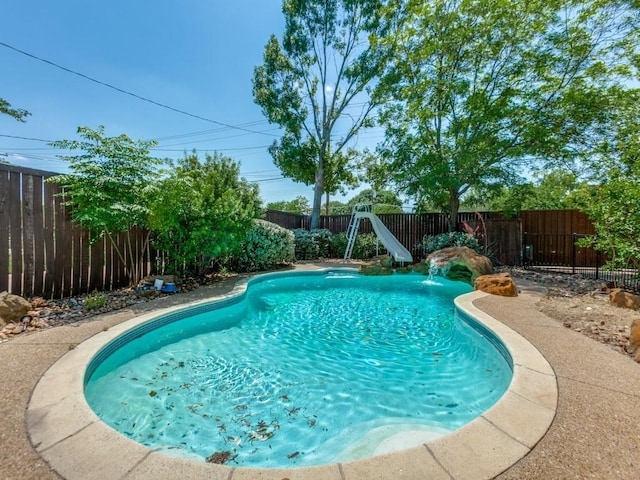 1135 La Mesa Dr, Richardson, TX 75080 - view of swimming pool featuring a water slide and a fenced backyard