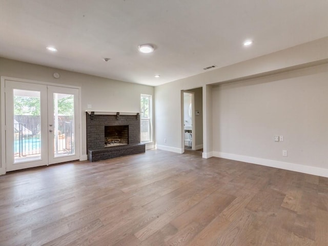 1135 La Mesa Dr, Richardson, TX 75080 - unfurnished living room featuring french doors, plenty of natural light, wood finished floors, and recessed lighting