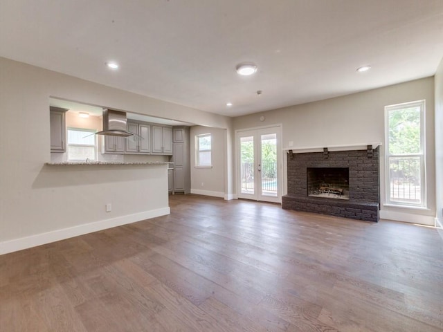 1135 La Mesa Dr, Richardson, TX 75080 - unfurnished living room featuring wood finished floors, a fireplace, baseboards, recessed lighting, and a sink