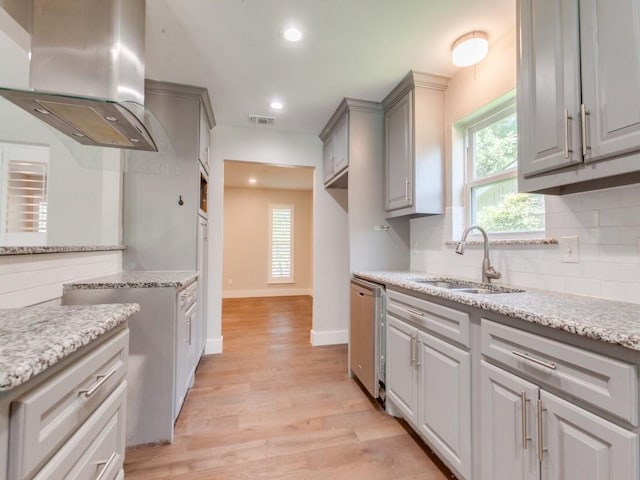 1135 La Mesa Dr, Richardson, TX 75080 - kitchen featuring island exhaust hood, a sink, gray cabinets, light wood-style floors, and decorative backsplash