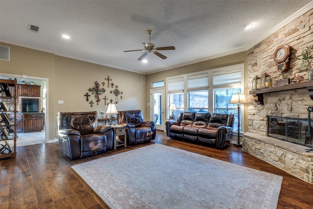 5891 Harmony Ranch Rd, Aubrey, TX 76227 - living area with ornamental molding, a ceiling fan, hardwood / wood-style flooring, a textured ceiling, and a stone fireplace