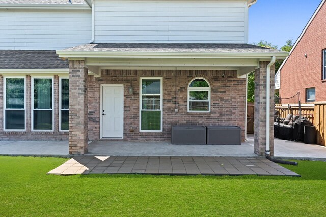3148 Guadaloupe, Grand Prairie, TX 75054 - view of exterior entry with a patio, brick siding, and roof with shingles