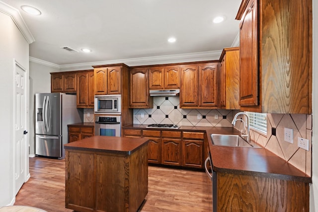 3148 Guadaloupe, Grand Prairie, TX 75054 - kitchen featuring stainless steel appliances, under cabinet range hood, dark countertops, ornamental molding, and a sink