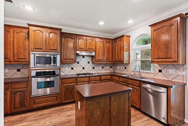 3148 Guadaloupe, Grand Prairie, TX 75054 - kitchen with appliances with stainless steel finishes, a sink, dark countertops, crown molding, and light wood-type flooring