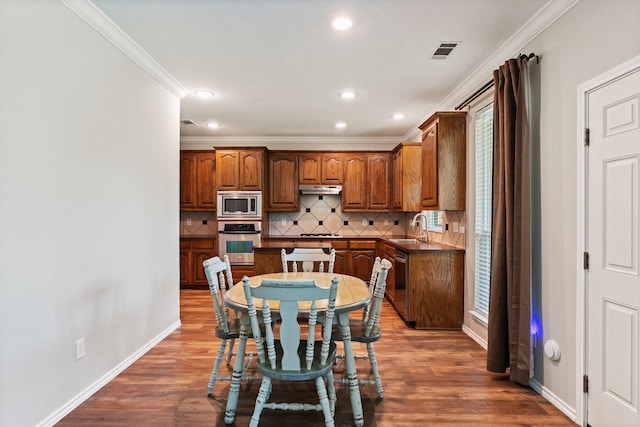 3148 Guadaloupe, Grand Prairie, TX 75054 - kitchen with appliances with stainless steel finishes, a sink, dark countertops, crown molding, and backsplash
