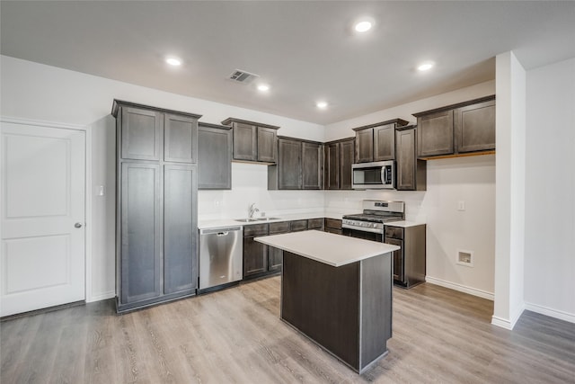 2112 Steer Creek Pl, Mesquite, TX 75149 - kitchen with stainless steel appliances, baseboards, dark brown cabinets, light wood finished floors, and a center island