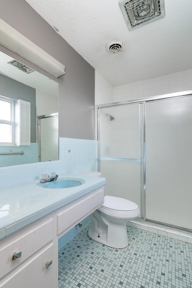 403 W China St, Brady, TX 76825 - bathroom featuring toilet, a shower stall, vanity, tile patterned flooring, and a textured ceiling