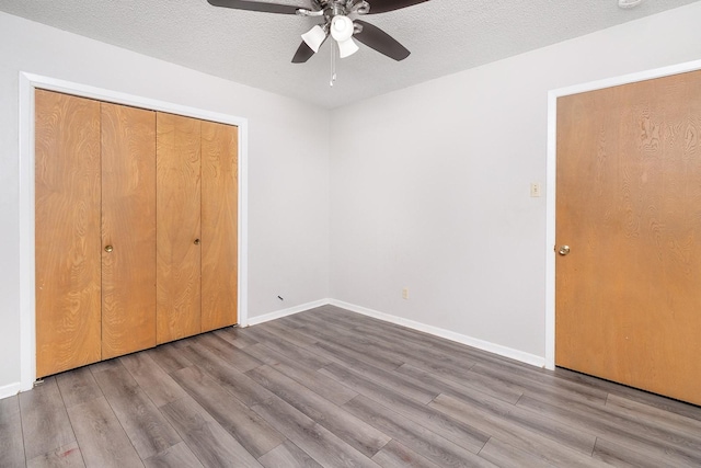 403 W China St, Brady, TX 76825 - unfurnished bedroom featuring wood finished floors, baseboards, a closet, ceiling fan, and a textured ceiling