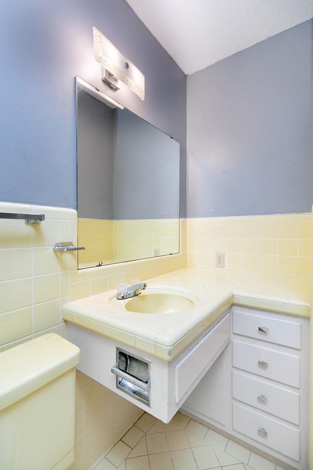 403 W China St, Brady, TX 76825 - half bath with toilet, tile patterned flooring, vanity, and a textured ceiling