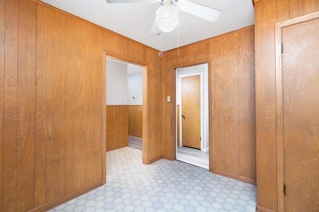 403 W China St, Brady, TX 76825 - unfurnished room with ceiling fan, wooden walls, and tile patterned floors