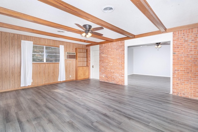 403 W China St, Brady, TX 76825 - empty room with ceiling fan, beamed ceiling, wood walls, wood finished floors, and baseboards