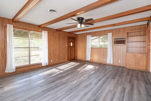 403 W China St, Brady, TX 76825 - spare room with beamed ceiling, wood walls, a ceiling fan, wood finished floors, and a wall unit AC