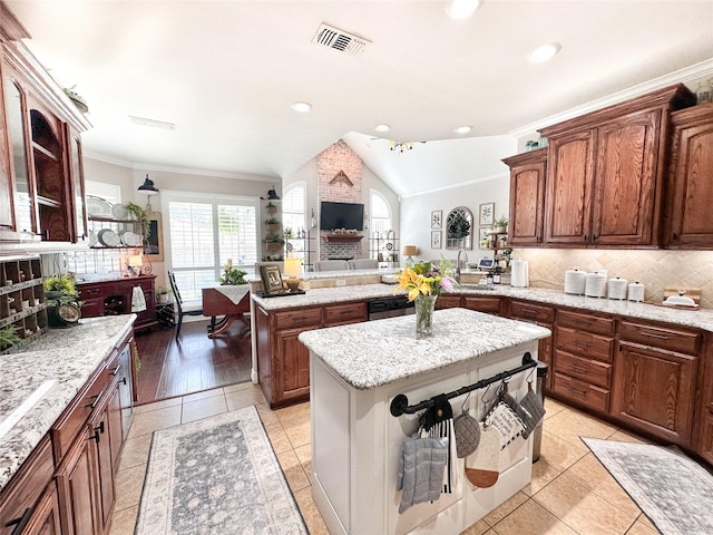599 N Weldon, Frankston, TX 75763 - kitchen featuring vaulted ceiling, decorative backsplash, ornamental molding, a peninsula, and a center island