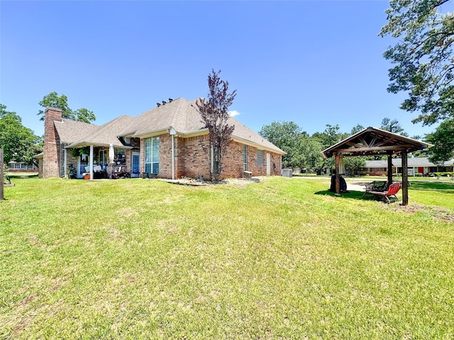 599 N Weldon, Frankston, TX 75763 - back of property featuring a gazebo, a lawn, brick siding, a chimney, and roof with shingles