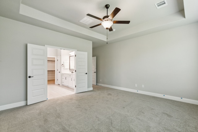 1105 Alaska, Forney, TX 75126 - unfurnished bedroom with a tray ceiling, light carpet, baseboards, ensuite bathroom, and ceiling fan