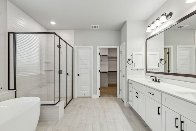 1105 Alaska, Forney, TX 75126 - bathroom with a shower stall, double vanity, a freestanding tub, a walk in closet, and wood finished floors