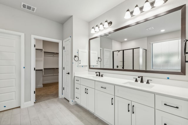 1105 Alaska, Forney, TX 75126 - full bathroom with a shower stall, double vanity, a spacious closet, wood finished floors, and baseboards
