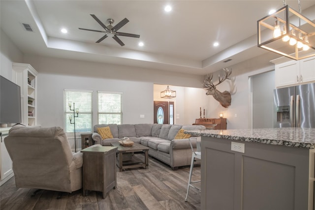 17294 Hidden Valley Ln, Flint, TX 75762 - living room with a tray ceiling, dark wood-style flooring, a ceiling fan, a chandelier, and recessed lighting