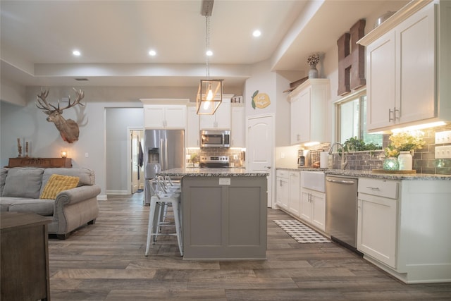 17294 Hidden Valley Ln, Flint, TX 75762 - kitchen featuring appliances with stainless steel finishes, open floor plan, white cabinetry, a kitchen island, and decorative backsplash