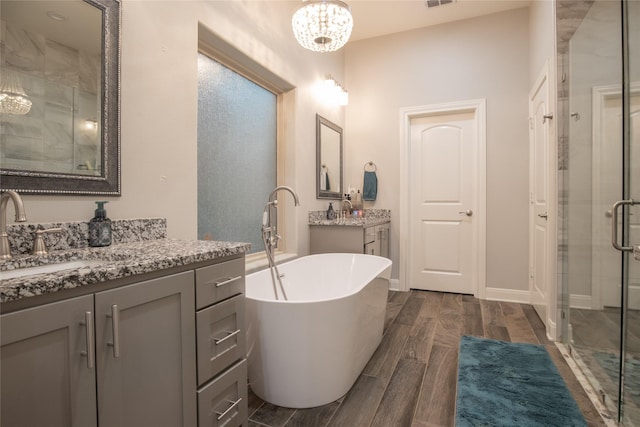 17294 Hidden Valley Ln, Flint, TX 75762 - full bath with a shower stall, a chandelier, two vanities, a freestanding tub, and wood finished floors