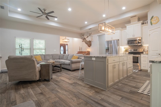 17294 Hidden Valley Ln, Flint, TX 75762 - kitchen with appliances with stainless steel finishes, open floor plan, a kitchen island, light stone countertops, and decorative backsplash