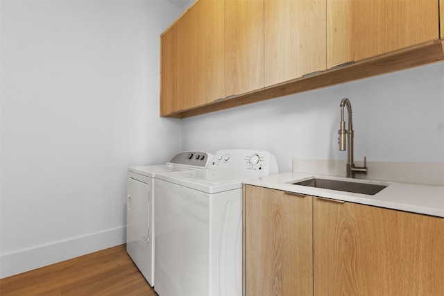 3941 Adrian Dr, Dallas, TX 75209 - laundry room with cabinet space, washing machine and clothes dryer, light wood finished floors, and baseboards