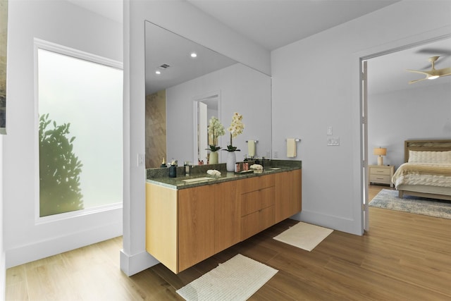 3941 Adrian Dr, Dallas, TX 75209 - full bath with double vanity, connected bathroom, wood finished floors, baseboards, and recessed lighting